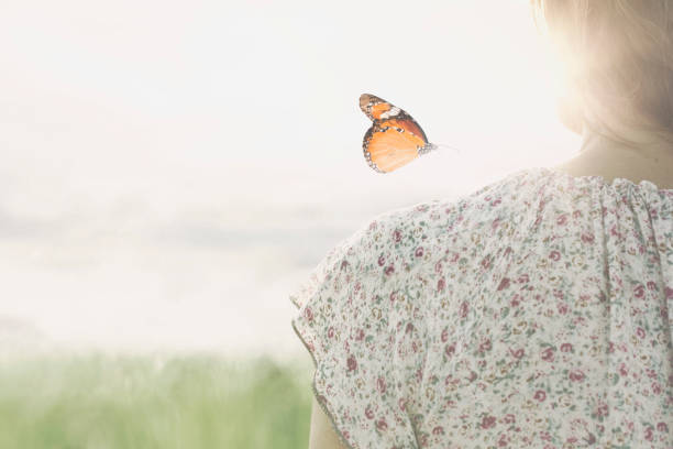 オレンジ色のアゲハ蝶と女性