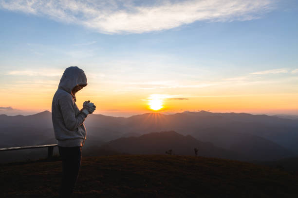 夕日に祈る女性