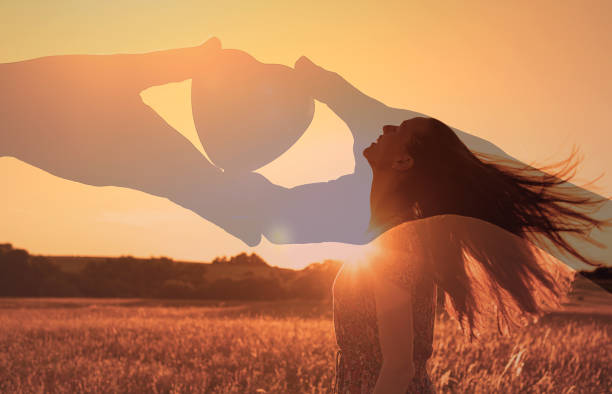 夕焼けの空に浮かぶ手の中のハート