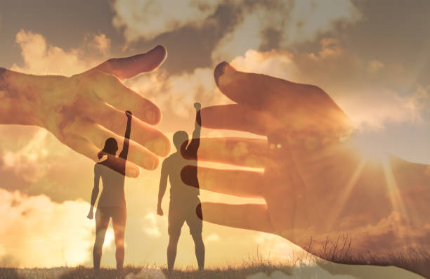 夕日に向かって右手を上げる男女