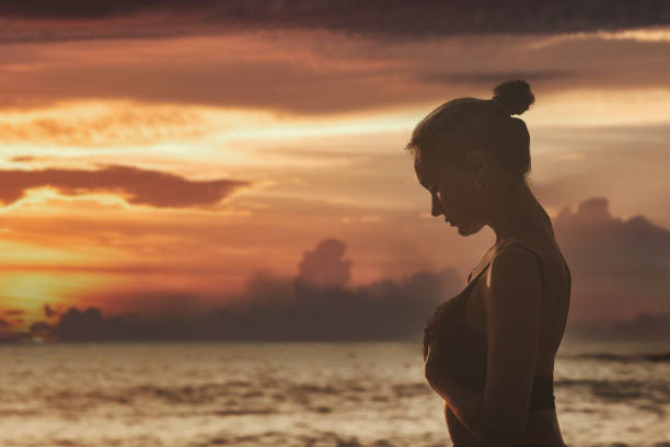 夕焼けと胸に手を当てる女性